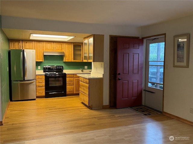 kitchen featuring stainless steel refrigerator, sink, black range with electric stovetop, and light hardwood / wood-style floors