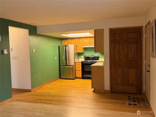 kitchen with stainless steel refrigerator, black electric range oven, and light wood-type flooring