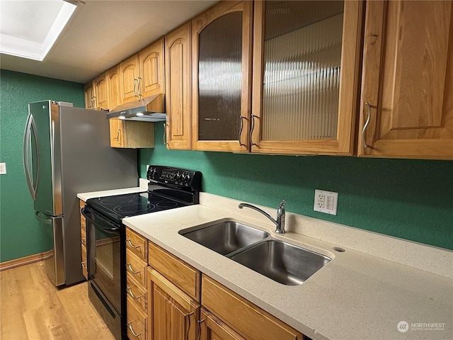 kitchen with sink, black electric range oven, and light wood-type flooring