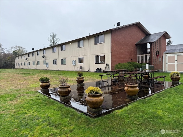 rear view of property with a patio, a storage unit, and a lawn