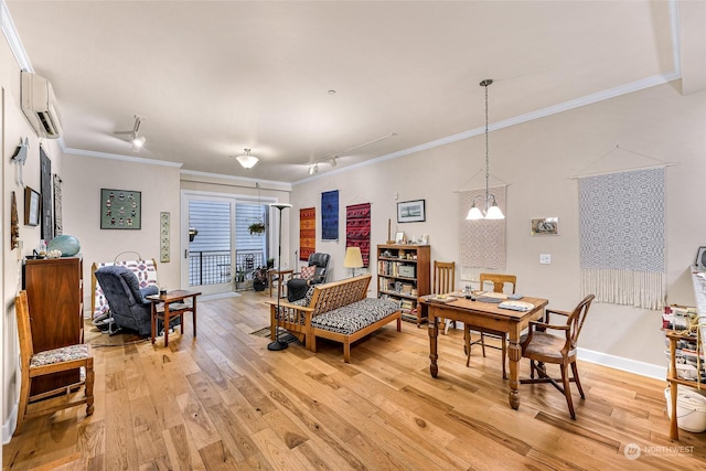 living room with rail lighting, a notable chandelier, a wall unit AC, light wood-type flooring, and ornamental molding