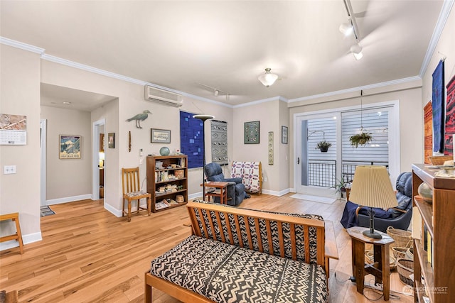 living room featuring an AC wall unit, crown molding, track lighting, and light wood-type flooring