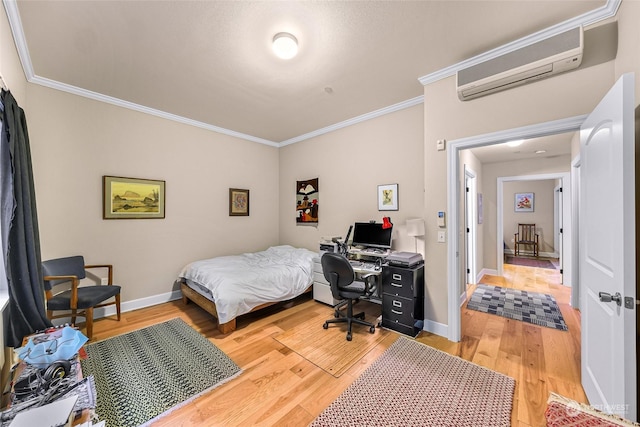 bedroom featuring a wall mounted AC, ornamental molding, and hardwood / wood-style flooring