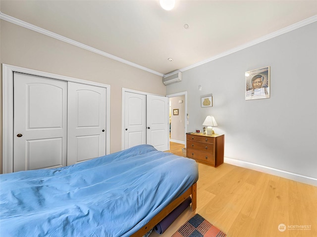 bedroom with a wall mounted air conditioner, hardwood / wood-style floors, and ornamental molding