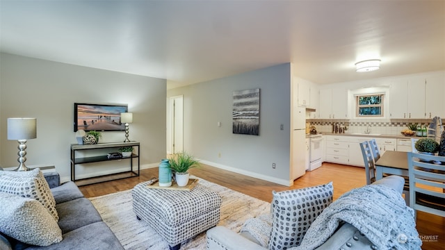 living room with light wood-type flooring and sink