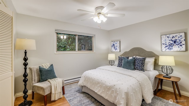 bedroom with ceiling fan, a closet, wood-type flooring, and a baseboard radiator