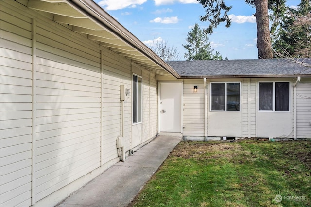 view of exterior entry featuring a lawn