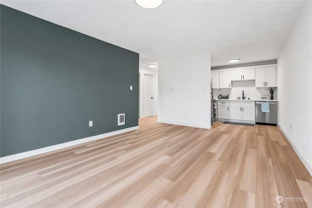 unfurnished living room featuring light hardwood / wood-style flooring and sink