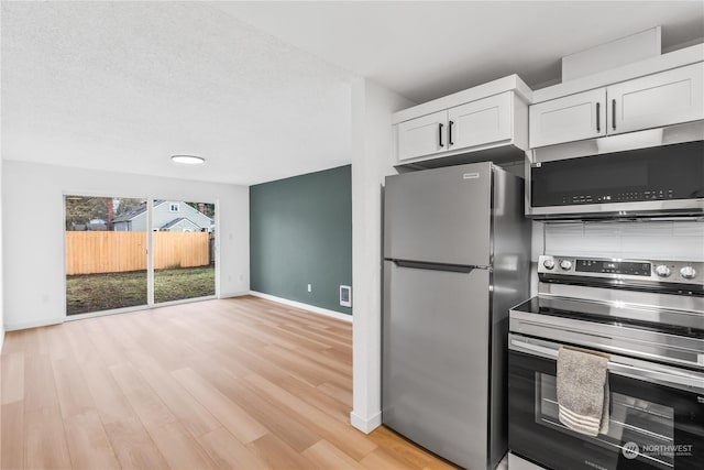 kitchen with stainless steel appliances, light wood-type flooring, and white cabinetry