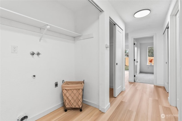 washroom featuring light hardwood / wood-style flooring and hookup for an electric dryer