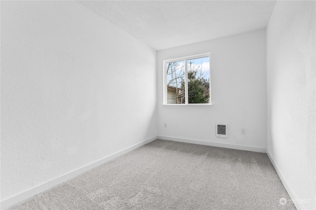 carpeted empty room featuring a textured ceiling