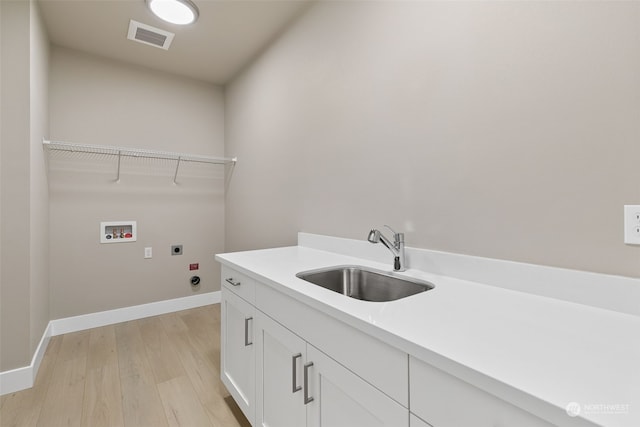 laundry area with sink, cabinets, hookup for an electric dryer, light hardwood / wood-style flooring, and hookup for a washing machine