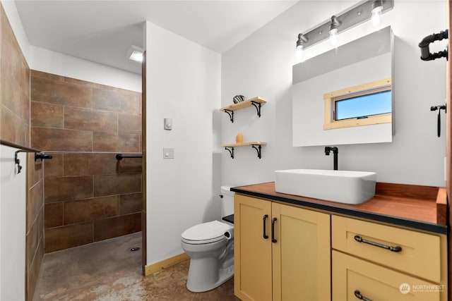 bathroom featuring vanity, toilet, and tiled shower