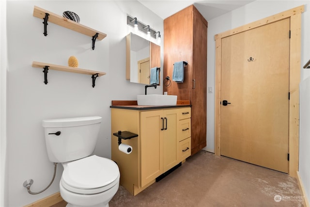 bathroom featuring concrete flooring, vanity, and toilet