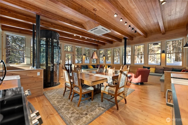 interior space featuring beamed ceiling, track lighting, plenty of natural light, and wood ceiling