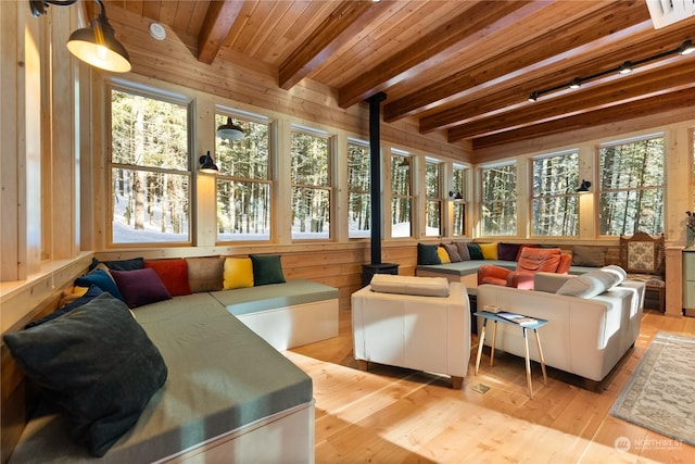 sunroom featuring beam ceiling, a healthy amount of sunlight, and wood ceiling