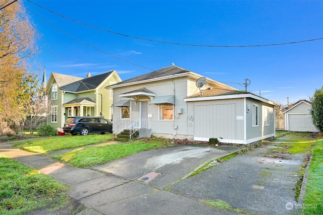 view of front facade with a front yard, a garage, and an outdoor structure