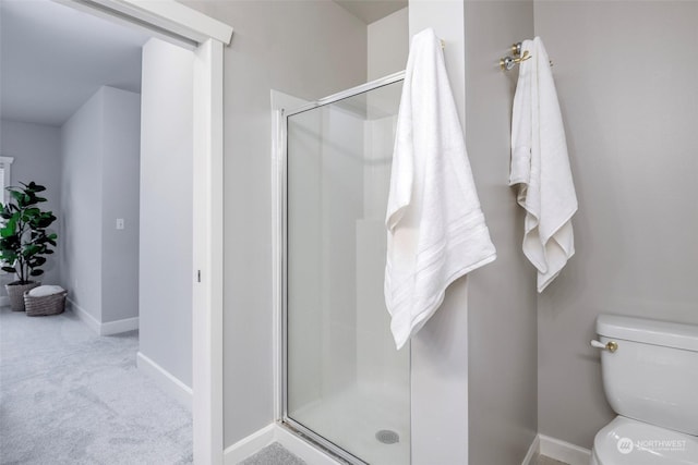 bathroom with toilet and an enclosed shower