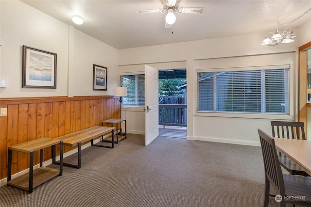 interior space featuring carpet and ceiling fan with notable chandelier