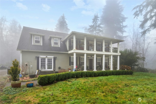 back of house with a balcony, french doors, and a lawn