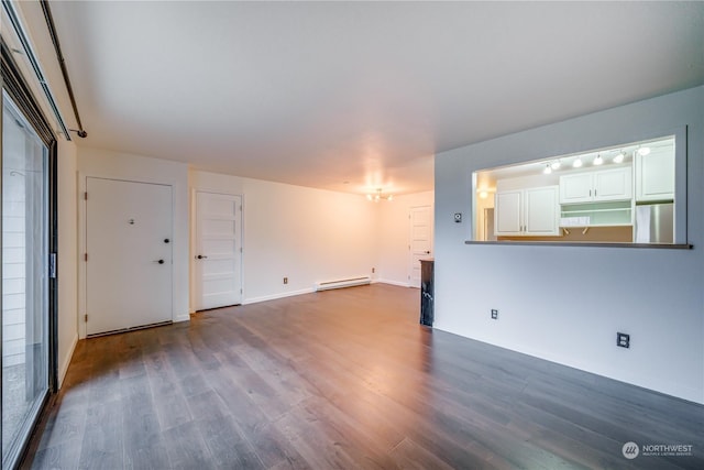 spare room featuring dark wood-type flooring and a baseboard radiator