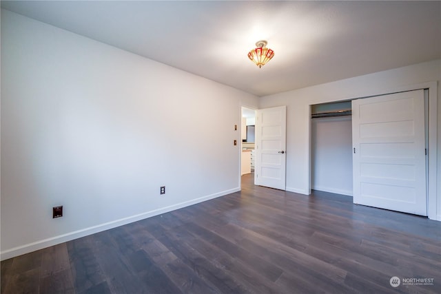 unfurnished bedroom with a closet and dark wood-type flooring