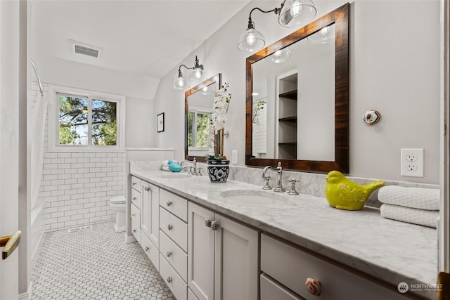 bathroom with toilet, vanity, and tile patterned floors