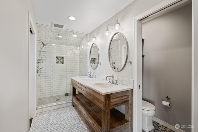 bathroom featuring toilet, vanity, tile patterned floors, and an enclosed shower