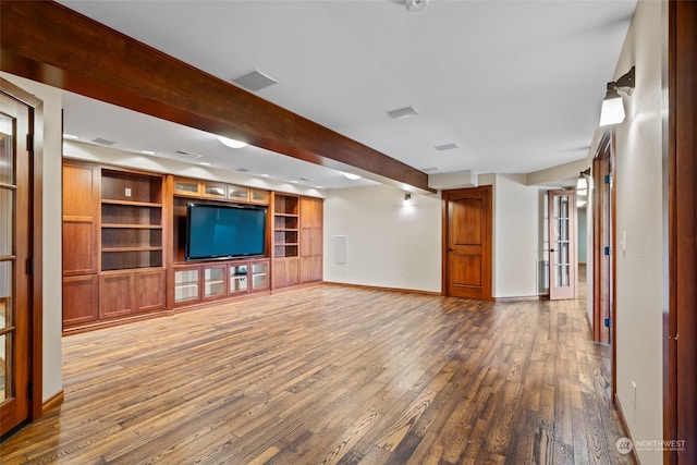 unfurnished living room featuring hardwood / wood-style flooring, built in features, and beamed ceiling