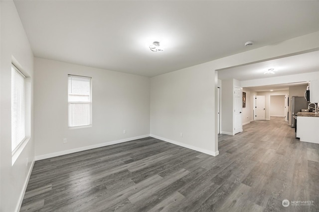 unfurnished room featuring dark hardwood / wood-style floors and sink