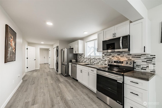 kitchen with sink, stainless steel appliances, tasteful backsplash, light hardwood / wood-style flooring, and white cabinets