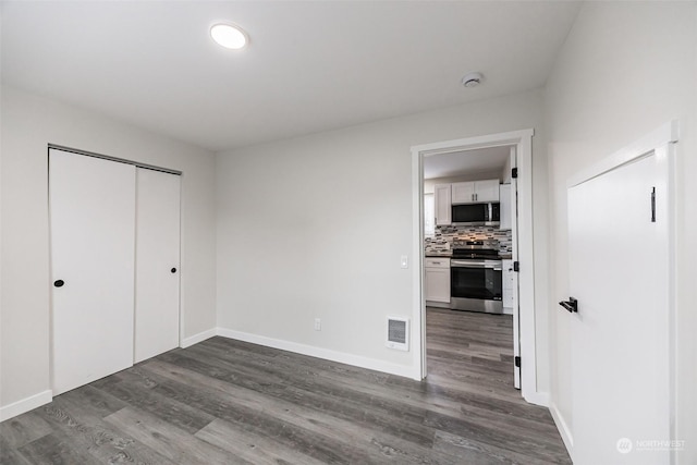 unfurnished bedroom with a closet and dark hardwood / wood-style floors