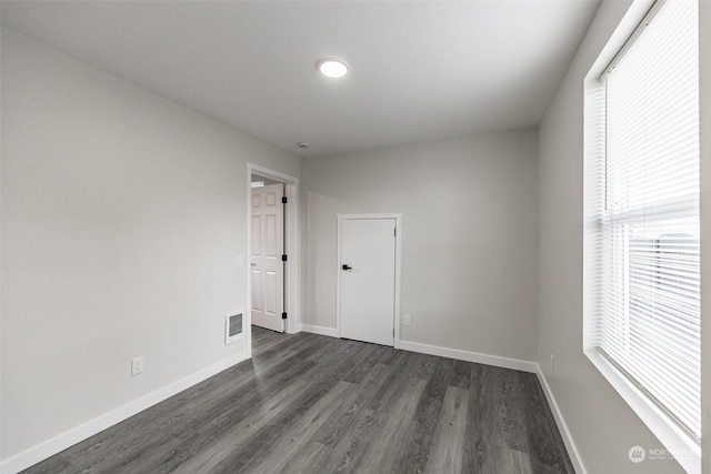 spare room with dark wood-type flooring