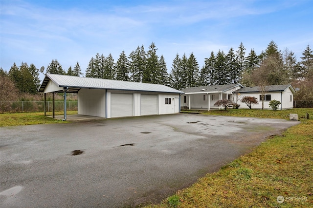 view of front of property with an outbuilding, a garage, a front yard, and a carport