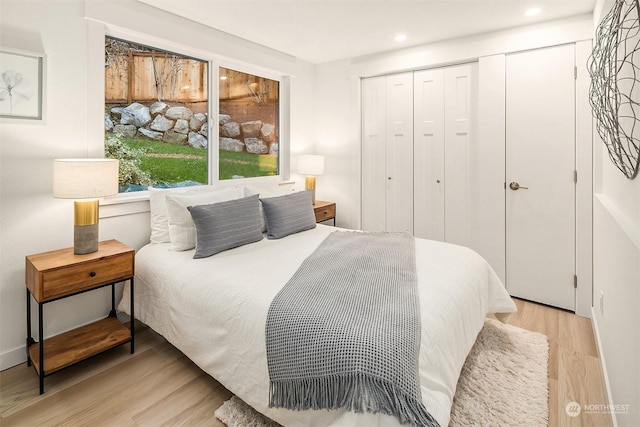 bedroom with light wood-type flooring and a closet