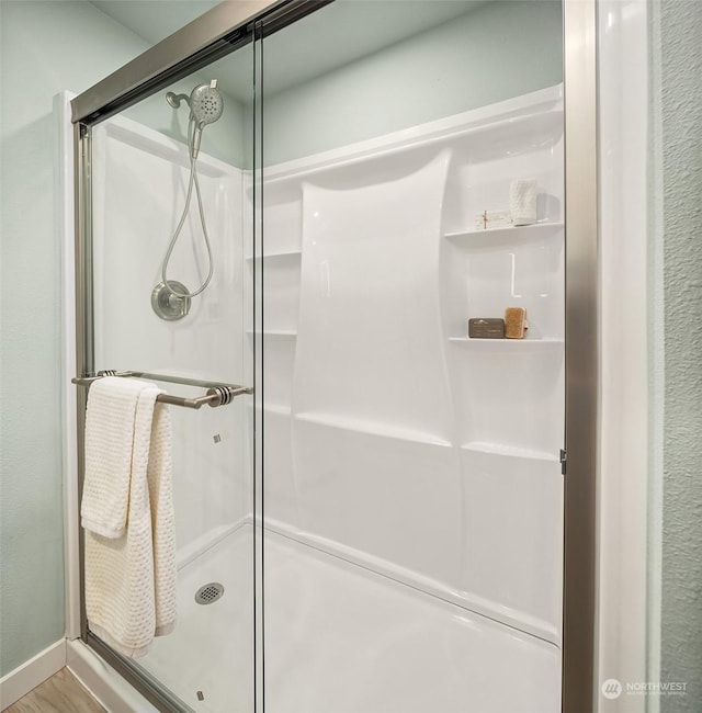 bathroom featuring wood-type flooring and a shower with shower door