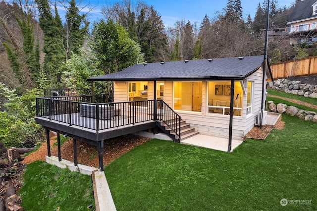 back of house featuring a lawn and a wooden deck