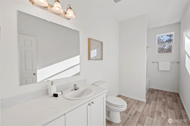 full bathroom with vanity, toilet, wood-type flooring, and shower / tub combo