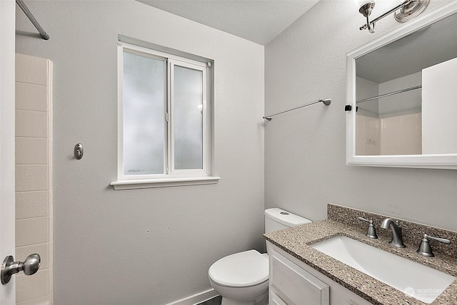 bathroom featuring vanity, a shower, and toilet