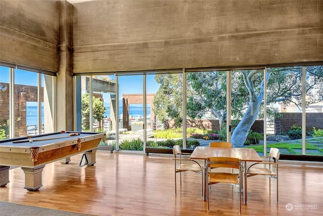 sunroom / solarium with a water view and billiards