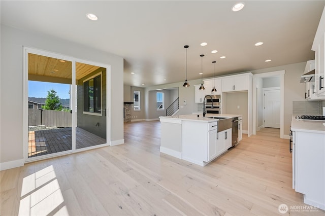 26521 NE 147th Pl Unit Sr 11, Duvall, WA 98019 - kitchen featuring white cabinetry, a sink, open floor plan, light wood-type flooring, and recessed lighting