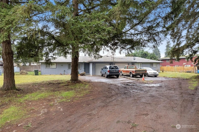 ranch-style house featuring a garage and a front lawn