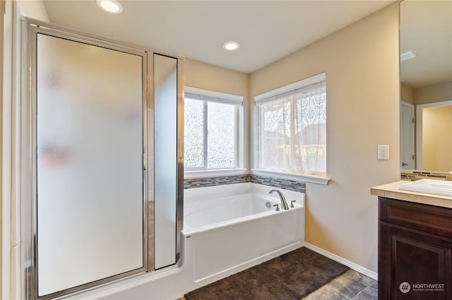 bathroom with vanity and shower with separate bathtub