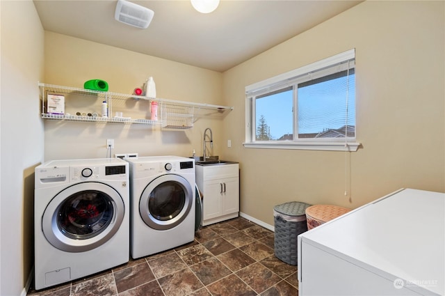 washroom with sink, cabinets, and washer and dryer