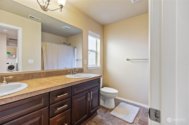 bathroom with toilet, washer / dryer, and vanity