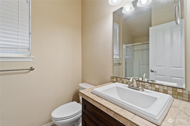 bathroom featuring a shower with shower door, toilet, and vanity