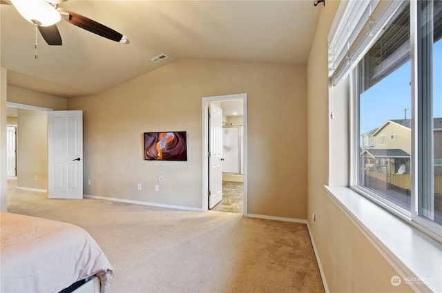 carpeted bedroom with ceiling fan, connected bathroom, and vaulted ceiling