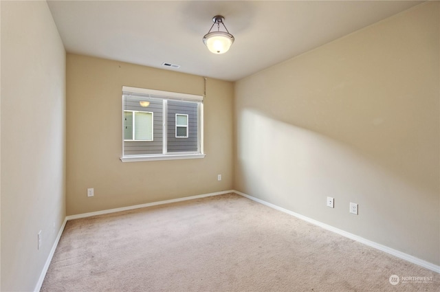 spare room featuring light carpet