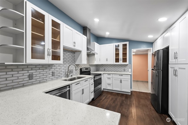 kitchen with white cabinetry, wall chimney exhaust hood, light stone counters, decorative backsplash, and appliances with stainless steel finishes