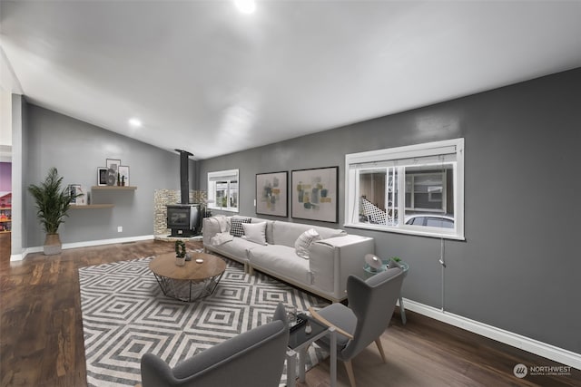 living room featuring a wood stove, wood-type flooring, and lofted ceiling